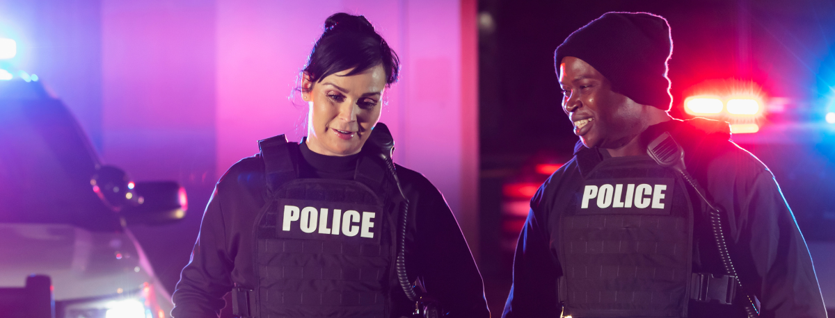 Two smiling police officers during field training.